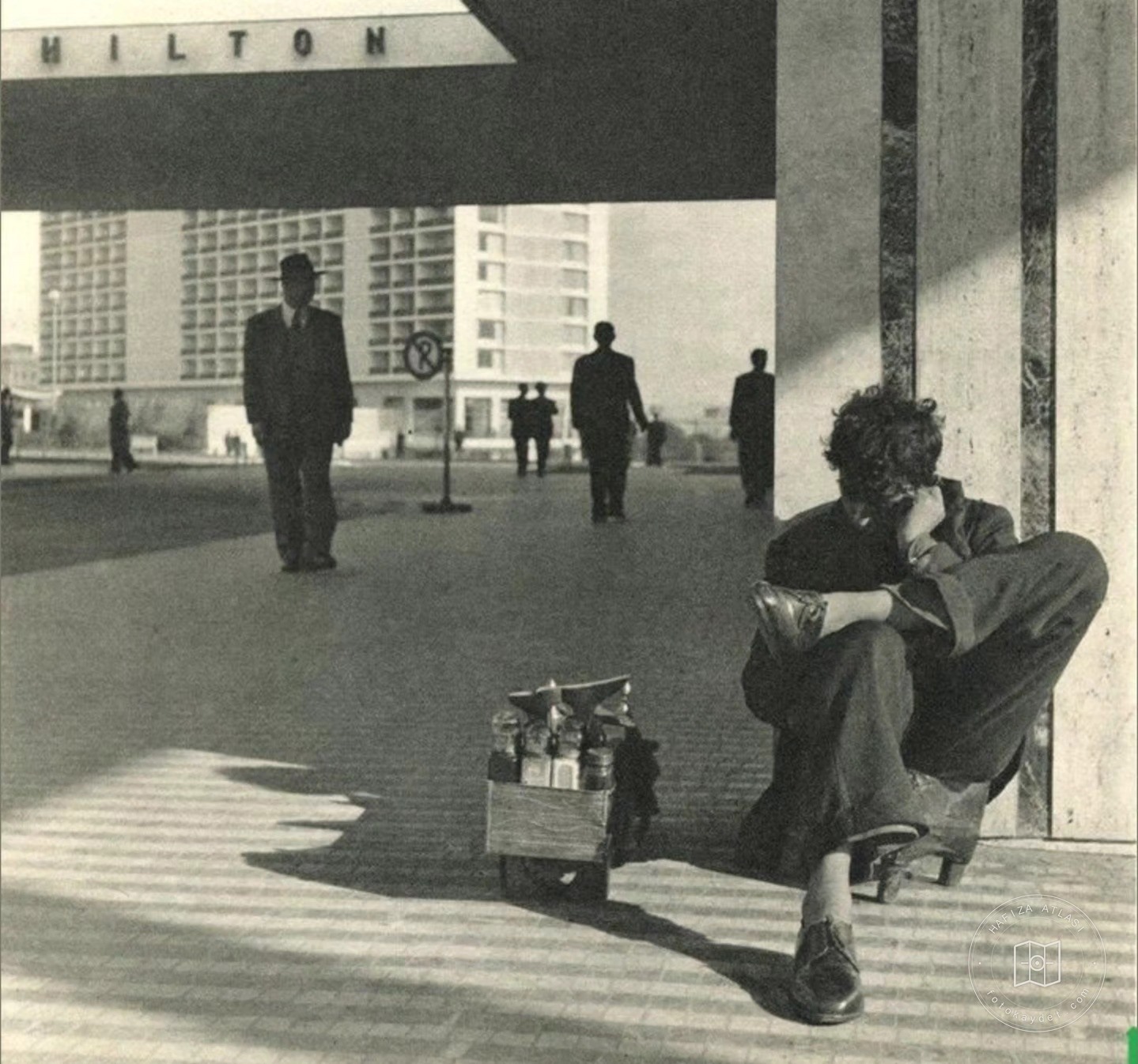 A shoeshiner outside the Hilton Hotel, 1957
