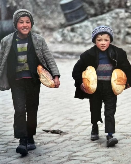 Two children carrying bread