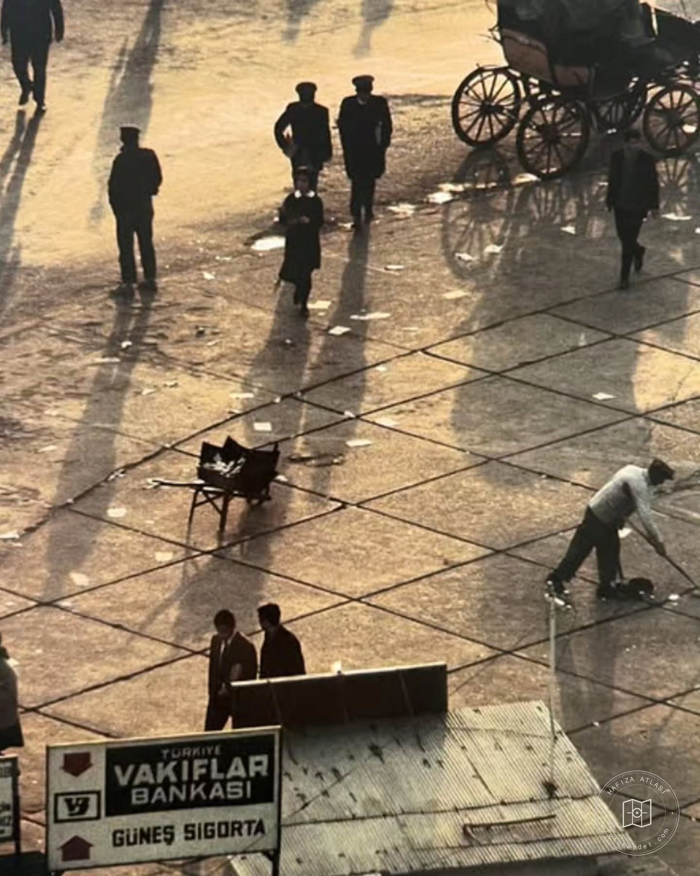Pedestrians and horse-drawn carriages in a square