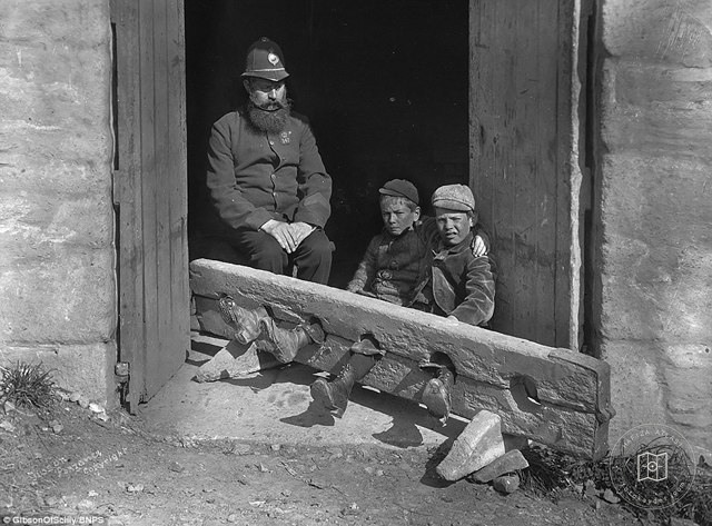 Two children being punished on Old Street in London, around 1900