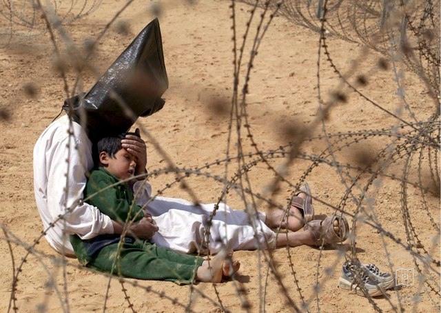 A prisoner of war comforting his son in Najaf, 2003