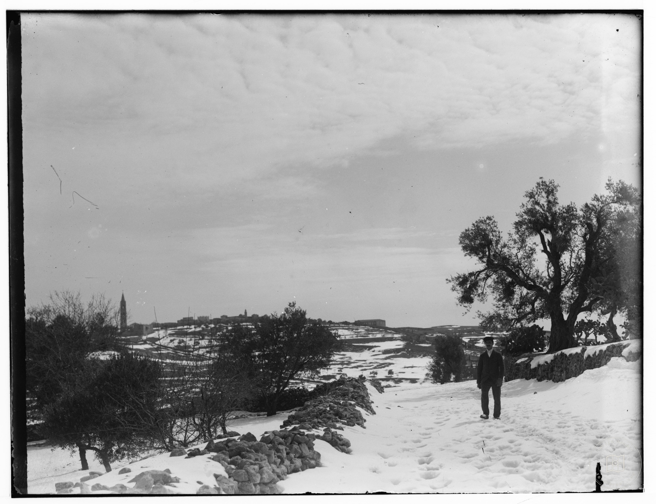 Snow in Jerusalem, 1921. View of Jerusalem from a distance with a man
