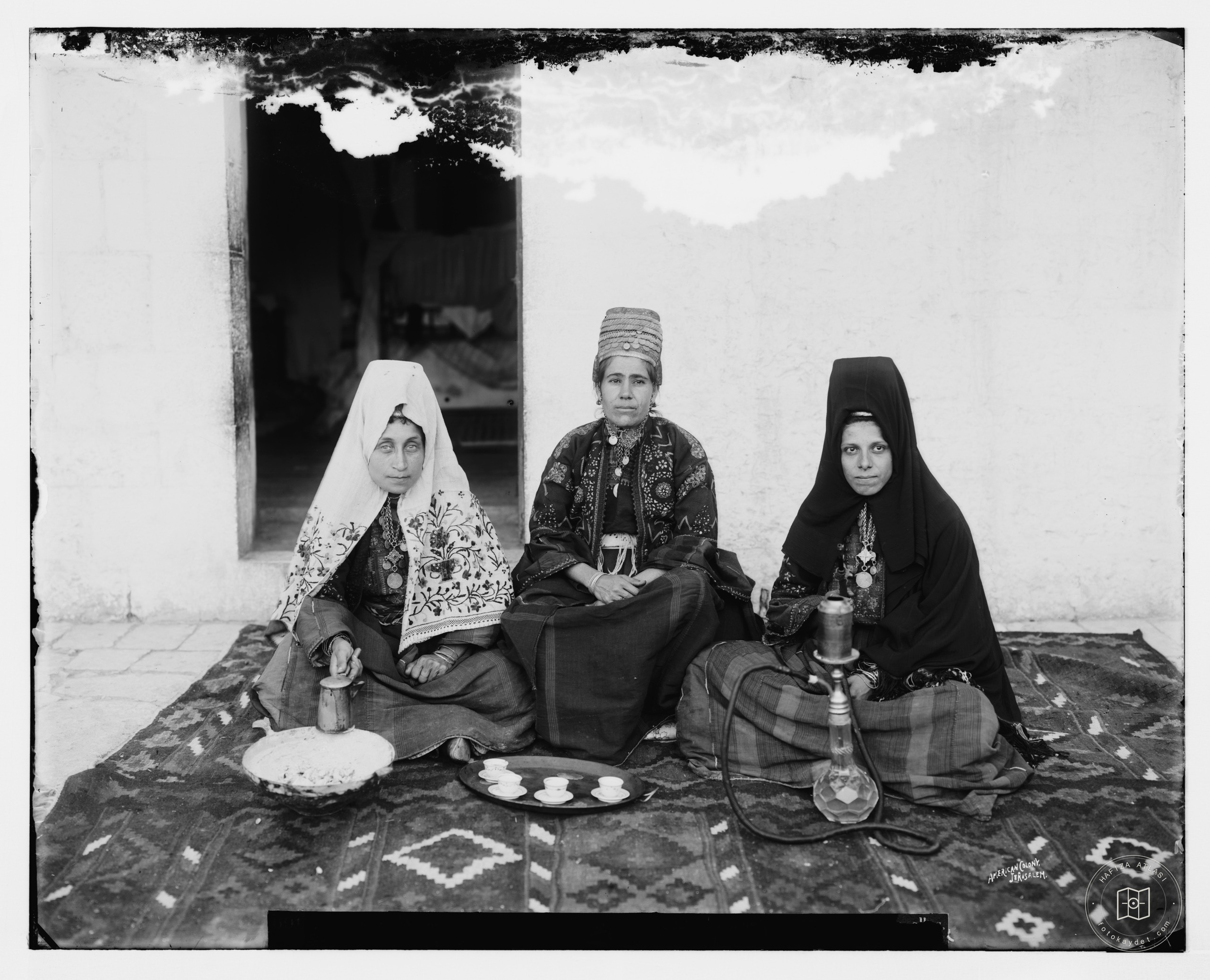 Three women seated on carpet, Bethlehem