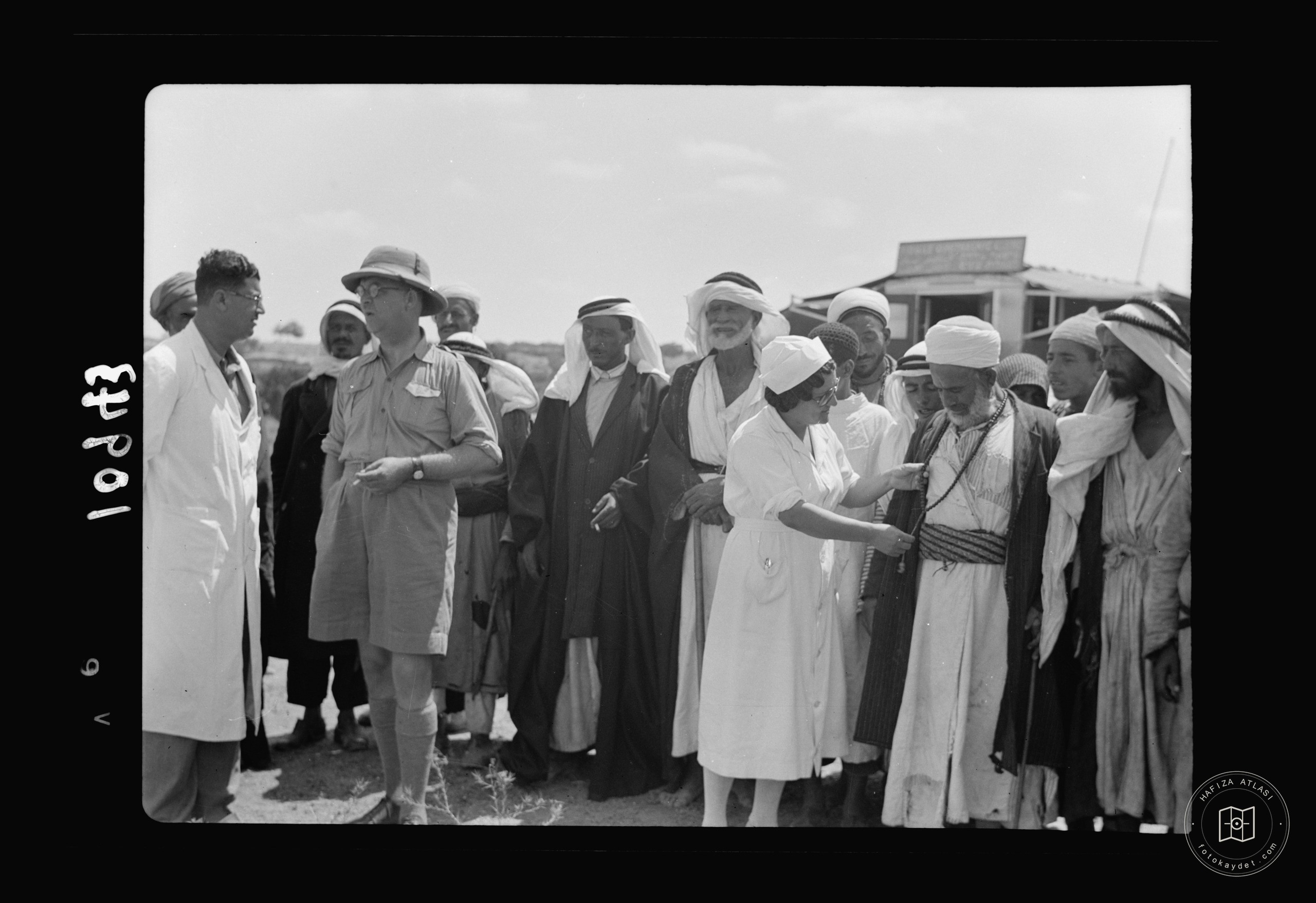 Group of Arabs from countryside mixing with doctors & nurses — mobile eye clinic near Gaza