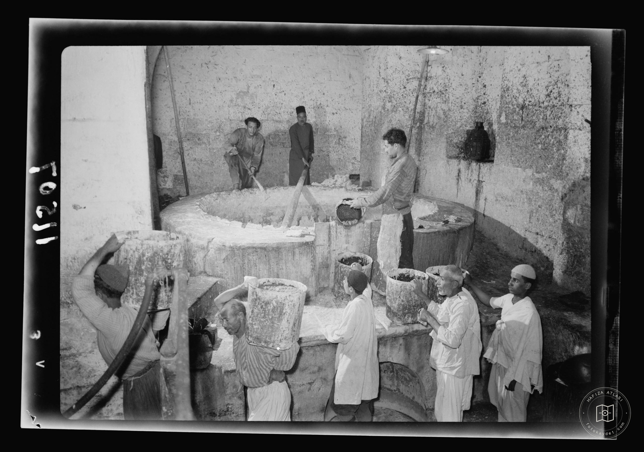 The Soap Factory. The boiling pot liquid soap being carried to stock room, Nablus
