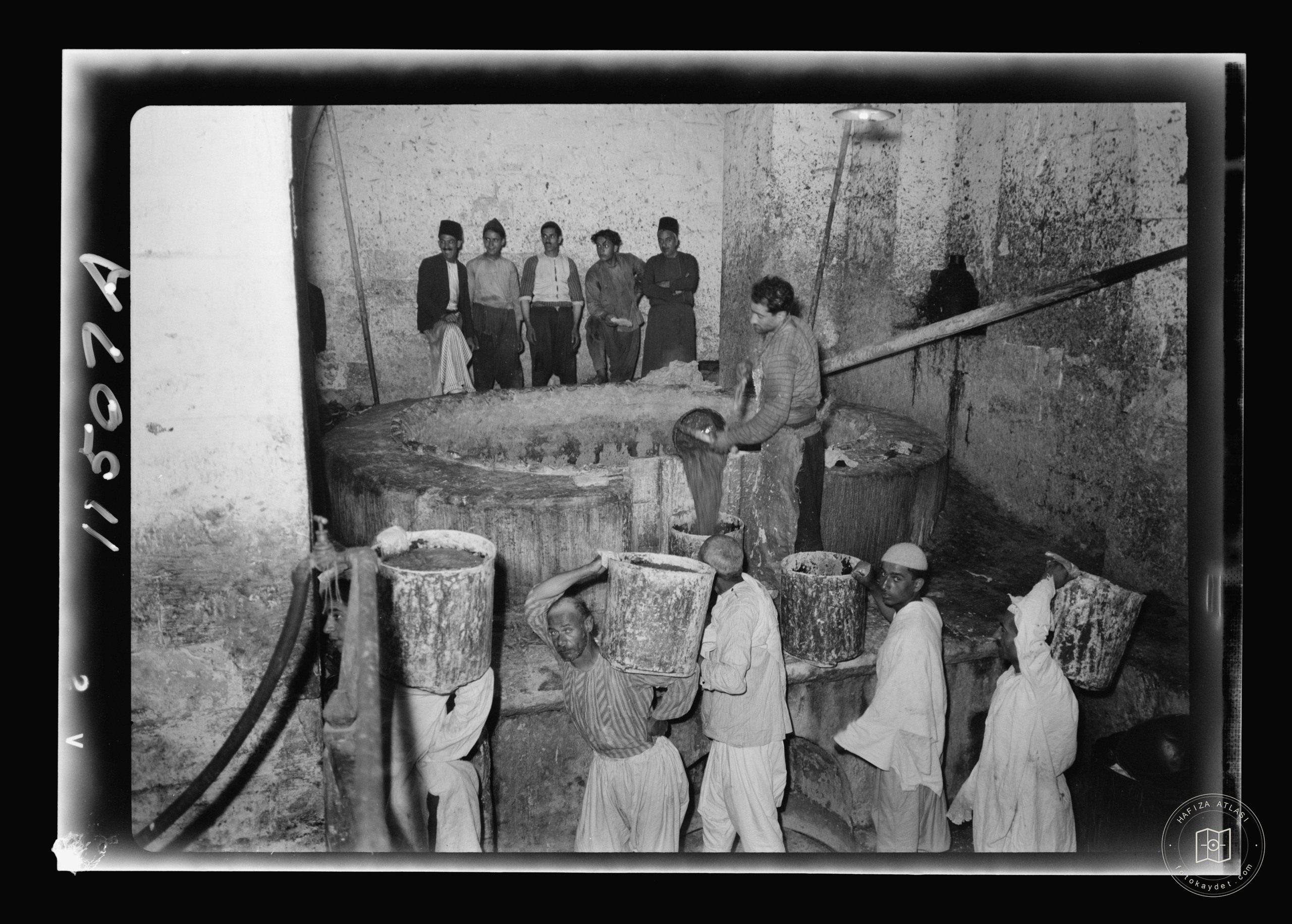 The Soap Factory. The boiling pot liquid soap being carried to stock room, Nablus
