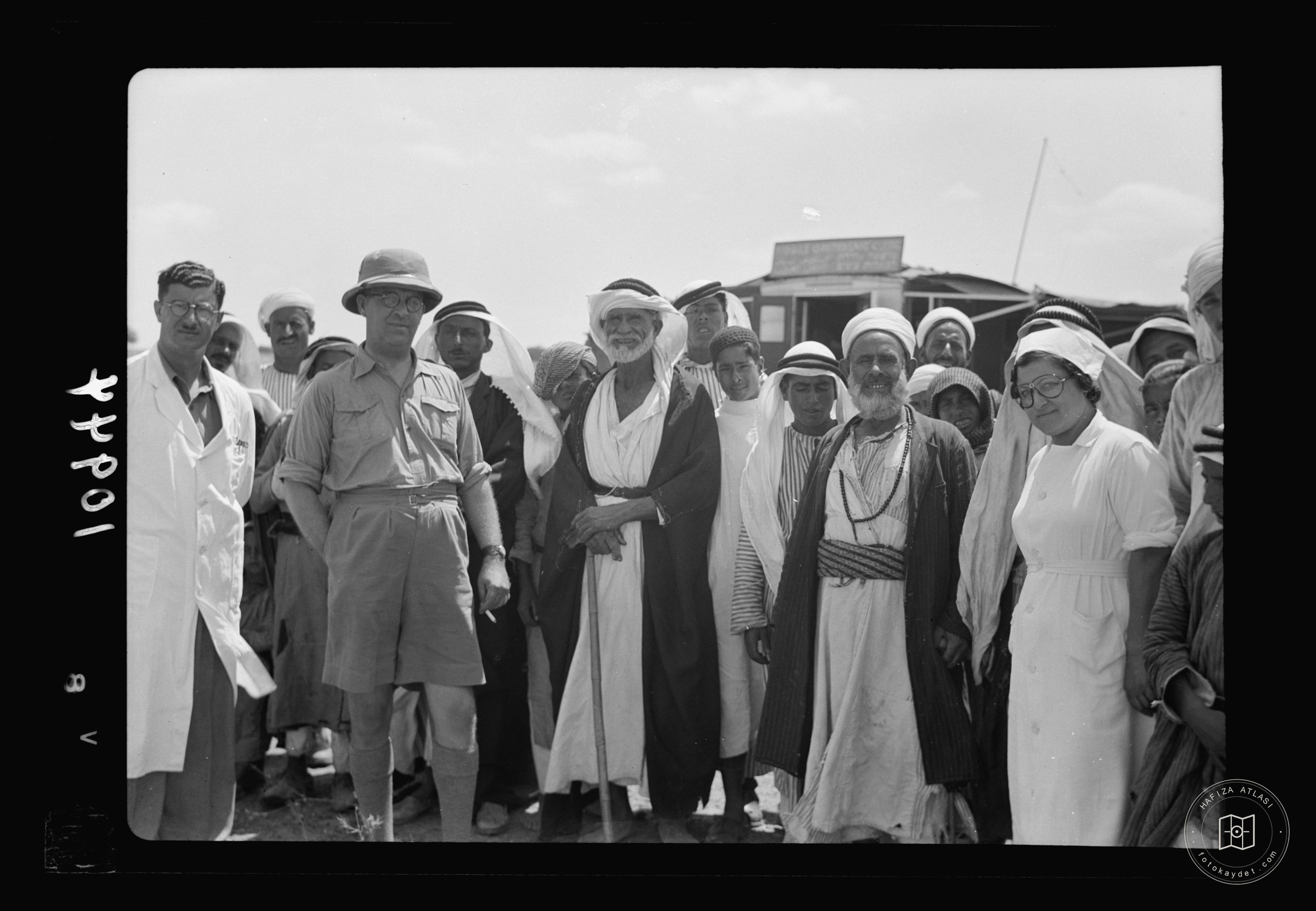Group of Arabs from countryside mixing with doctors & nurses, closer — mobile eye clinic near Gaza