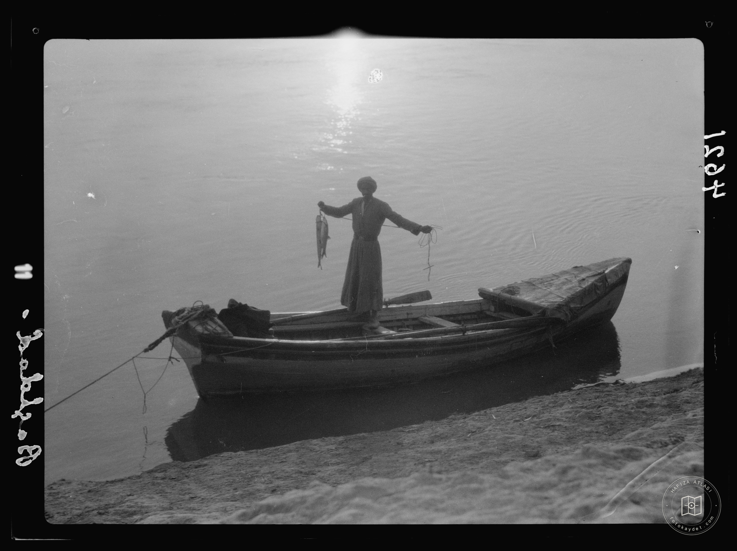 Baghdad. The Tigris. Silhouette of an angler in a boat with his catch