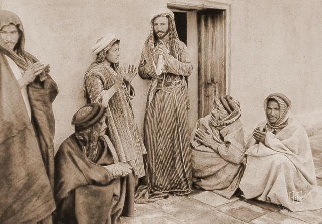 Iraq — Mullah teaching a prayer to a young man