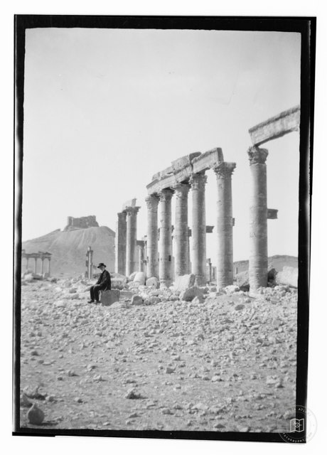 Palmira harabelerinde oturan bir adam