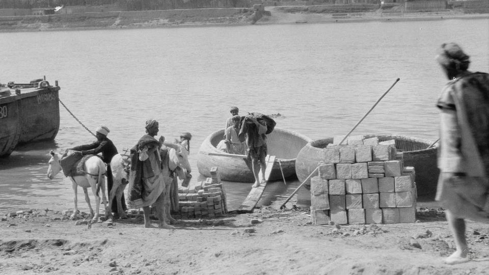 Baghdad. The Tigris. Unloading bricks from "ghuffas." Round basket boats